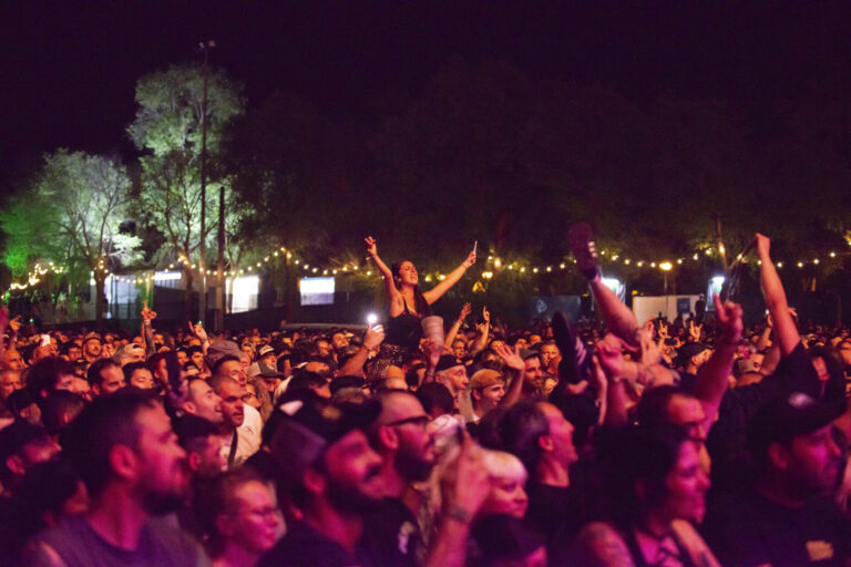 Público disfrutando de un concierto nocturno en el Azkena Rock Festival, con luces decorativas al fondo.
